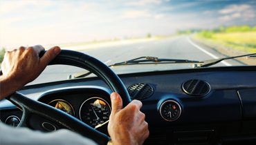 A driver at the wheel, shore transport for crew and inspectors